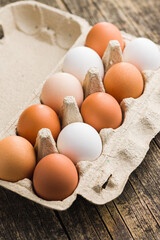 Poster - Whole chicken eggs in eggbox on wooden table.