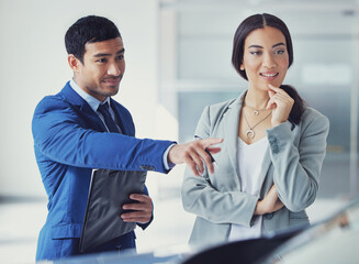 Poster - What about that one. a handsome young male car salesman talking to a female customer on the showroom floor.