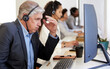 © Anela Ramba/peopleimages.com - I might just lose this sale. a mature call centre agent looking stressed out while working in an office with his colleagues in the background.