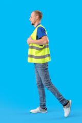 Wall Mural - Male worker in vest on blue background