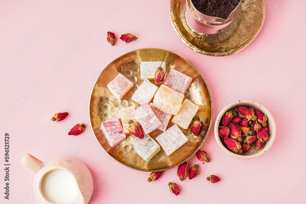 Plate with tasty Turkish delight on pink background