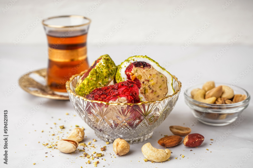 Bowl with tasty Turkish delight on light background