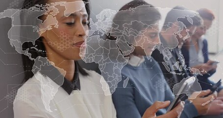 Canvas Print - Animation of map over diverse people sitting on chairs and using smartphone in office