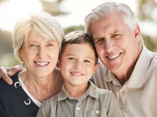 Poster - Portrait of loving caucasian grandparents enjoying time with grandson in nature. Smiling little boy bonding with grandmother and grandfather. Happy seniors and child smiling and looking at the camera