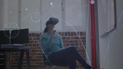 Poster - Animation of connections with icons over caucasian businesswoman wearing vr headset in office