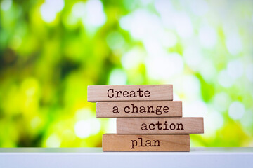 Wall Mural - Wooden blocks with words 'Create a change action plan'.