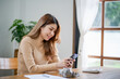 © Charlie's - Asian woman texting checking social media holding smartphone at home Conversation with boyfriend or friend.