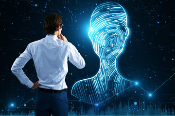Poster - Back view of young businessman looking at abstract digital fingerprint man or person silhouette on blurry blue background. Identity, technology and secure concept.