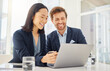 © Nicholas Felix/peopleimages.com - Business man, woman and laptop for planning, reading and happy with results in modern office. Japanese businesswoman, businessman and computer with diversity, teamwork and collaboration for strategy