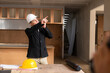 © ArLawKa - Young engineer giving radio commands to workers at construction site An architect or contractor speaks to the radio to supervise and plan the development of the house structure.