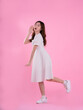 © STOCK88PHOTOGRAPHER - full body image of asian woman in skirt posing on pink background