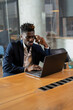 © JustLife - Portrait of successful businessman in office. Young smiling man talking to the phone..
