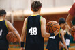 Youth basketball team on training. Basketball training session for school kids. Young basketball player with classic ball. Junior level basketball player holding game ball