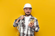 © Богдан Маліцький - male asian electrician in hard hat and glasses holds internet cable and phone on yellow background, korean worker