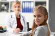 © H_Ko - Portrait of child girl at reception at the pediatrician doctor in clinic. Medical examination of children and insurance