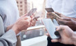 © Samir H/peopleimages.com - When you need to innovate, you need collaboration.. Cropped shot of a group of unrecognizable businesspeople using their cellphones.