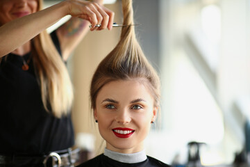 Wall Mural - Hairdresser hands cut off blonde tail closeup. Woman hairdresser cutting long blond hair with scissors in barbershop