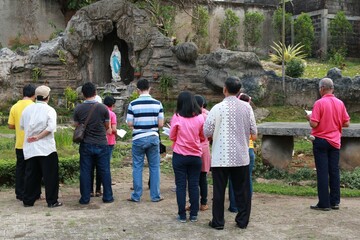 People praying in front of Maria cave. rRosary prayer. Catholic prayer