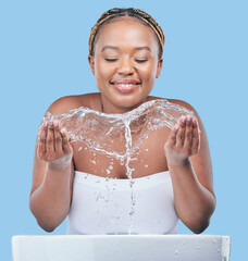 Poster - Your skin will always need moisture. Studio shot of an attractive young woman washing her face against a blue background.