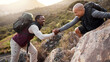 © Nicholas Felix/peopleimages.com - Lets get up this mountain together. Cropped shot of a handsome young man helping his friend along a mountain during their hike.