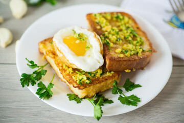 Sticker - Fried croutons in batter with garlic and herbs and a fried egg in a plate.