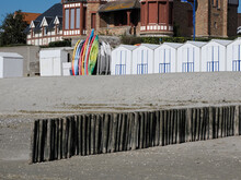 Beach Cabins With Little Boats And A Wave Breaker Made Of Wooden Stakes Of Town At Le Crotoy A Commune In The Somme Department In Hauts-de-France In Northern France 