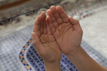 A person's hands are shown in front of a carpet with the words  prayer  on it.