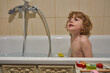 A little boy is taking a bath