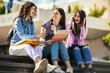 © Mediteraneo - Group of students with notebook studying together outdoors.