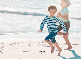 Dont let the waves catch you. Shot of an adorable little girl and boy having fun at the beach.