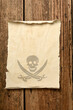 old parchment with skull and crossbones on an old wooden board