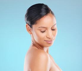 Wall Mural - Shes readiating beauty. Studio shot of an attractive young woman posing against a blue background.