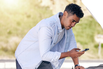 Poster - I need to call roadside assistance. Cropped shot of a handsome young man on the phone with roadside assistance after suffering a vehicle breakdown.