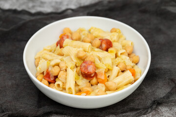 Sticker - chick pea with smoked sausages, pasta and cabbage in white bowl