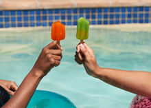 Close Up Of Friends Holding Ice Lolly Popsicles In The Swimming Pool, Beat Heat