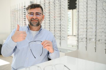 Glasses check, senior vision and elderly man at a consulting optometry clinic for wellness. Happy, smile and old face with lens, frame and eyewear choice in a store for help getting a prescription.