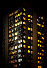 Wall Mural - Multi-storey building from the windows of which the light is on. AI Generated