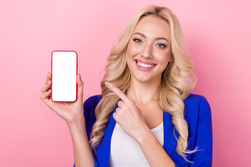 Portrait of pretty person beaming smile direct finger arm hold empty space telephone display isolated on pink color background