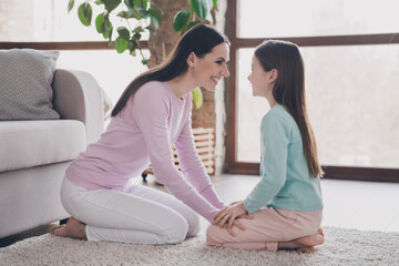 Photo of cute pretty mother daughter wear casual outfits sitting floor enjoying spending time together indoors house room