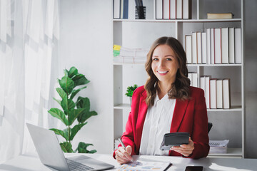 Happy Business woman entrepreneur holding calculator working sit at office desk. Portrait of beautiful smiling young businesswoman working at modern work station.