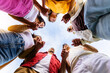 © Xavier Lorenzo - Low angle view of united group of young people in circle holding hands. Community, support and teamwork concept with millennial people showing unity outdoors.