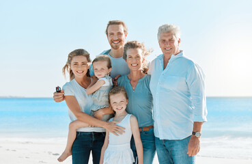 Poster - Every day with them is magical. Shot of a multi-generational family spending the day at the beach.