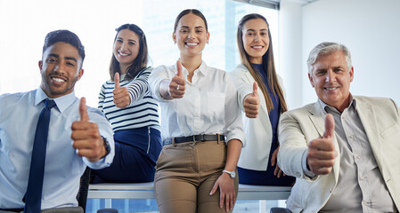 Poster - We love what we do. Shot of a group of businesspeople showing thumbs up at the office.