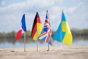 Wall Mural - Flags of Germany and France and Great Britain and Ukraine on the sand in Ukraine on the shore, flags of countries and friendship