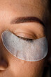© fesenko - close-up top view of female face with disposable paper patch under the eye. Eyelash extension