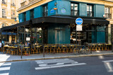 Fototapeta Uliczki - Cozy street with tables of cafe  in Paris, France. Cityscape of Paris. Architecture and landmarks of Paris