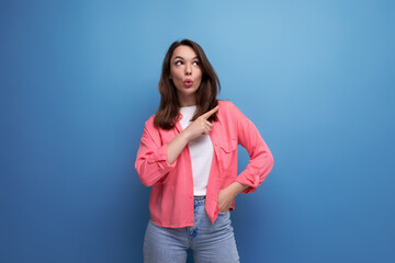 Canvas Print - joyful shocked brunette young woman in casual outfit communicates some idea over isolated background