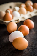 Poster - Whole chicken eggs on black table.