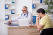 © Elnur - Young male patient visiting old male doctor radiologist