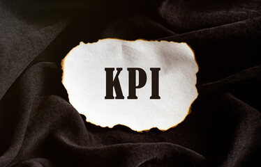 Poster - burned paper on a black background with text kpi